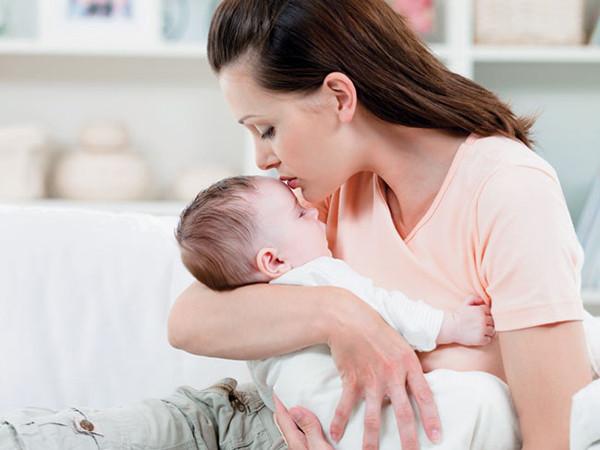 mẹ âu yếm ôm hôn bé