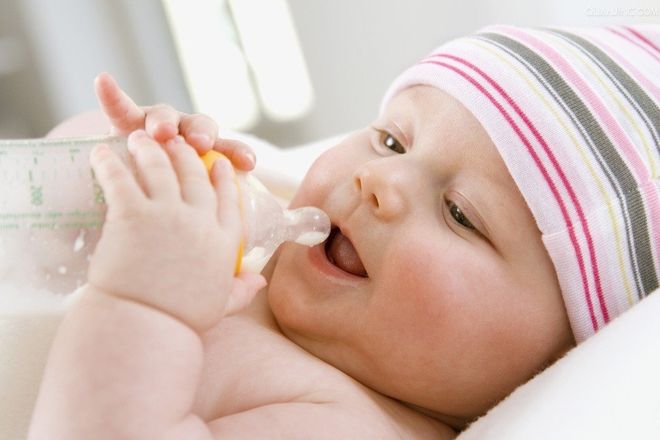 em bé cầm bình sữa bú