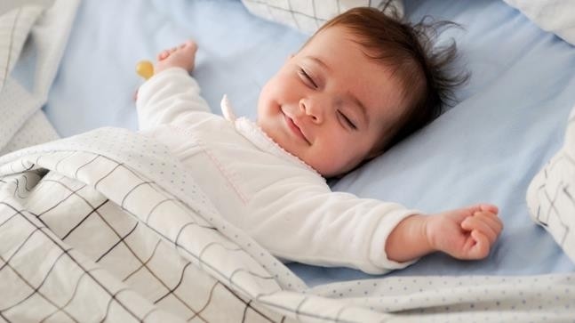 bé mỉm cười trong giấc ngủ