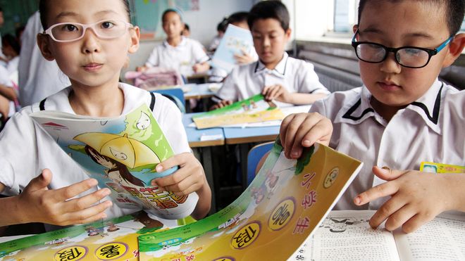 bé đeo kính đang lật sách