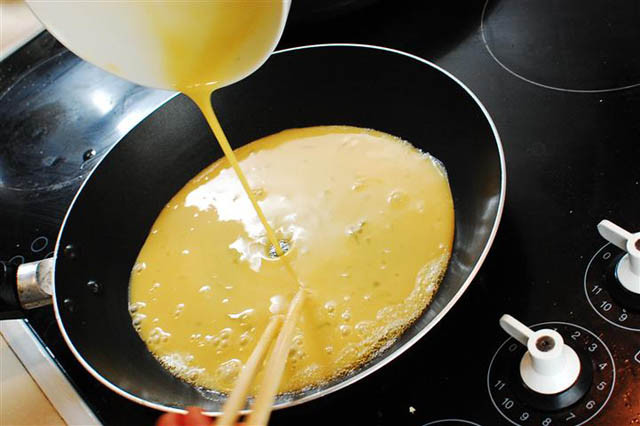 cho trứng vào chảo chiên vàng