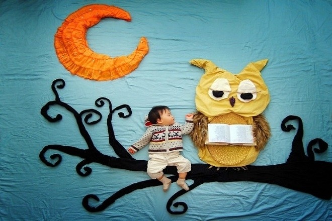 bé nằm ngủ cạnh chú chim cú mèo