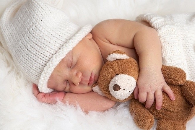 trẻ sơ sinh ôm gấu ngủ ngon trong không gian rộng