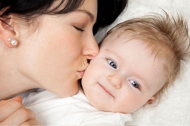 mẹ hôn má và âu yếu bé trước khi ngủ