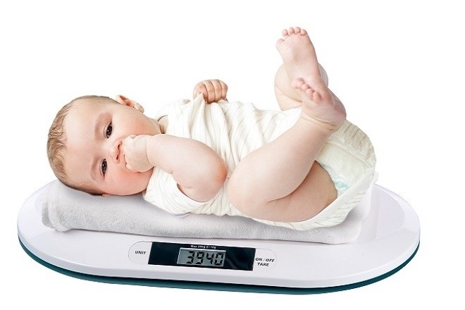 trẻ 9 tháng tuổi nằm cân đối để đo chính xác cân nặng