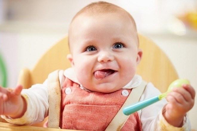 trẻ 9 tháng tuổi cầm nắm đồ dùng để ăn dặm