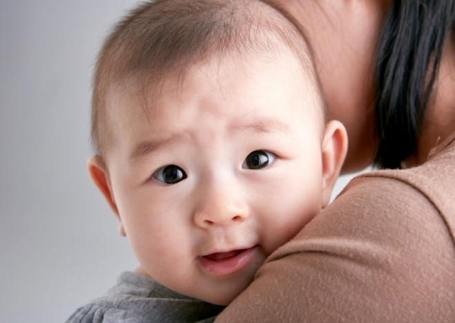 em bé được mẹ bế trên tay