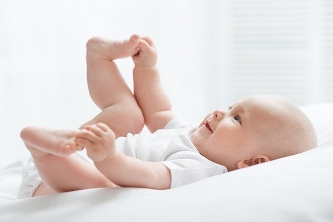 trẻ nằm chơi vui vẻ khi sức khỏe ổn định