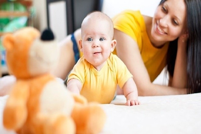 trẻ 4 tháng tuổi biết lật người dưới sự giám sát của mẹ