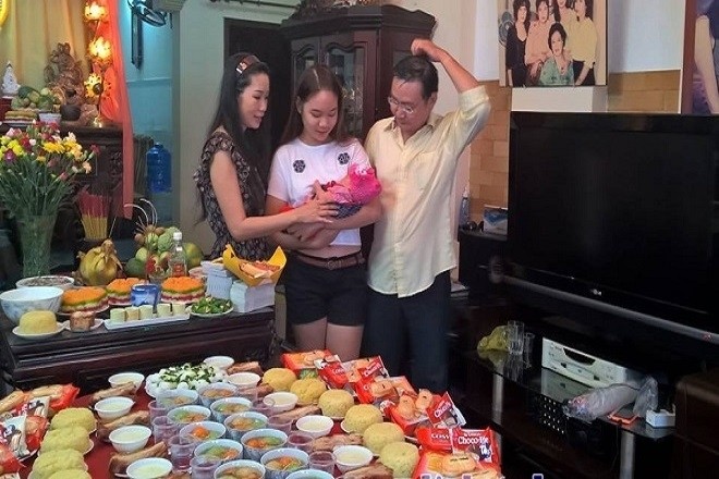 bé trai và gia đình bên mâm lễ cúng đầy tháng