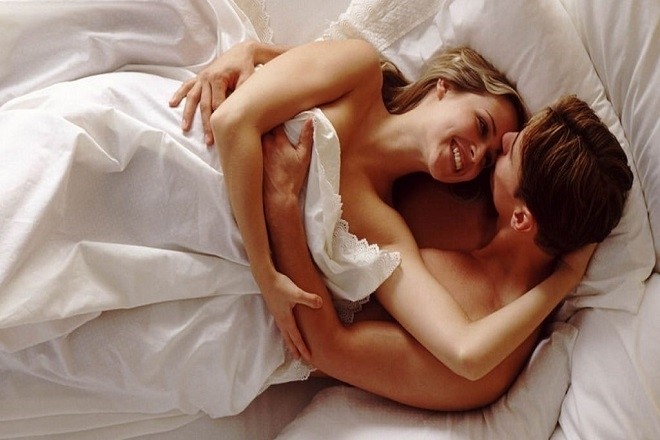 cặp đôi âu yếm nhau trên giường