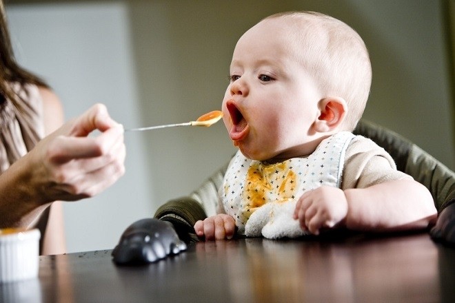 bé được mẹ đút đồ ăn dặm