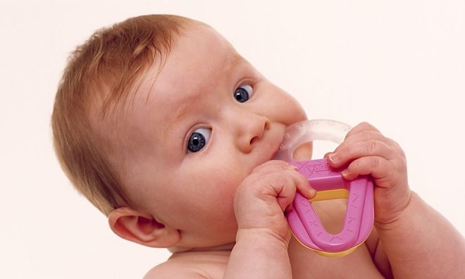bé ngậm đồ vật