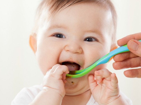 đưa muỗng bột vào miệng bé