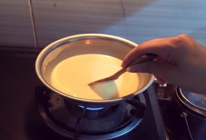 khuấy đều hỗn hợp sữa đặc đường sữa trộn và bột ngô trên bếp