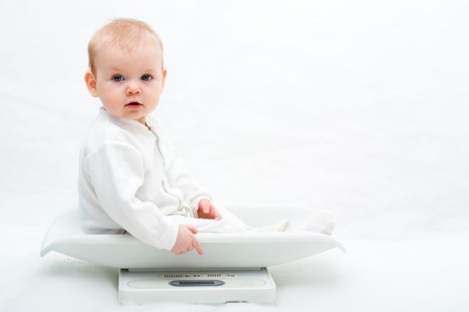 bé ngồi trên chiếc cân