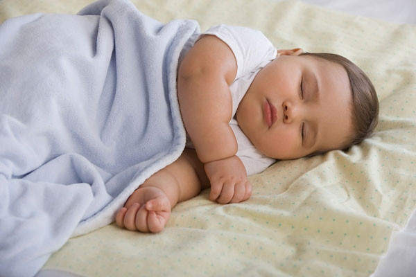 bé ngủ nằm nghiêng được đắp khăn