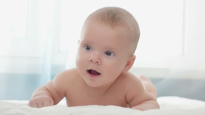 bé đang tập trườn trên nệm