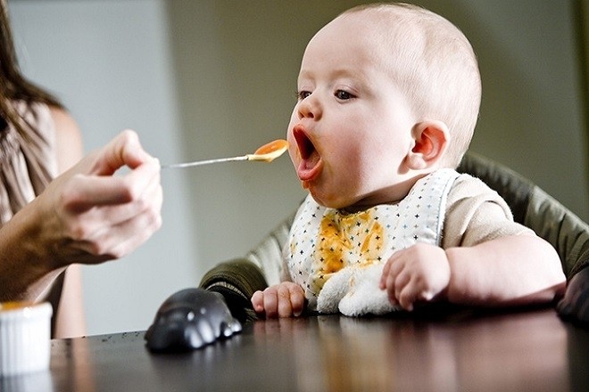 mẹ đang đút cháo ăn dặm cho bé 5 tháng tuổi