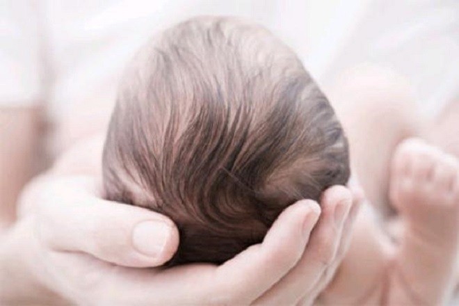 nâng niu phần đầu trẻ sơ sinh