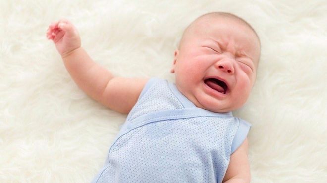 bé nằm trên nệm khóc gắt
