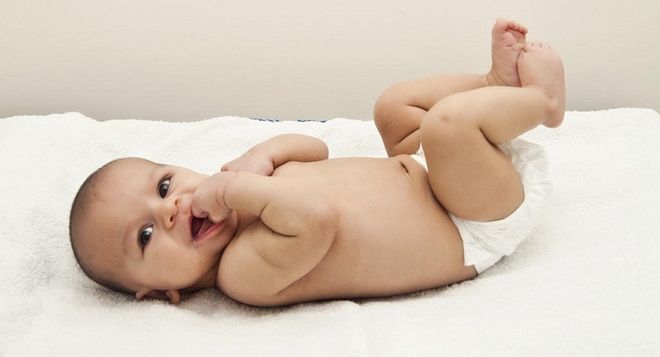 bé nằm trên nệm mút tay