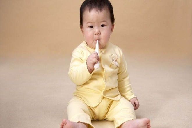 bé ngậm nhiệt kế trong miệng