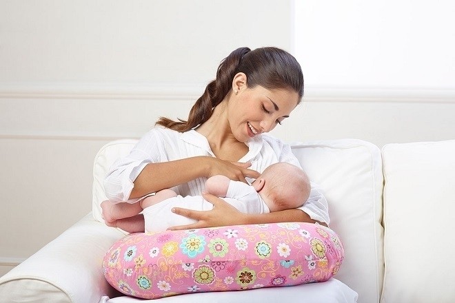 trẻ sơ sinh đang nằm bú sữa mẹ