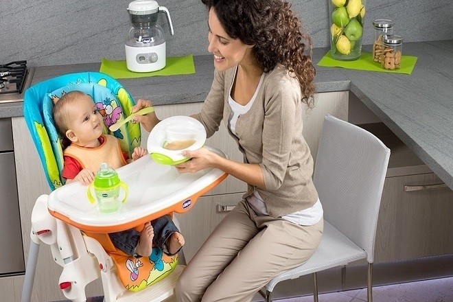 mẹ ngồi đút thức ăn dặm cho bé