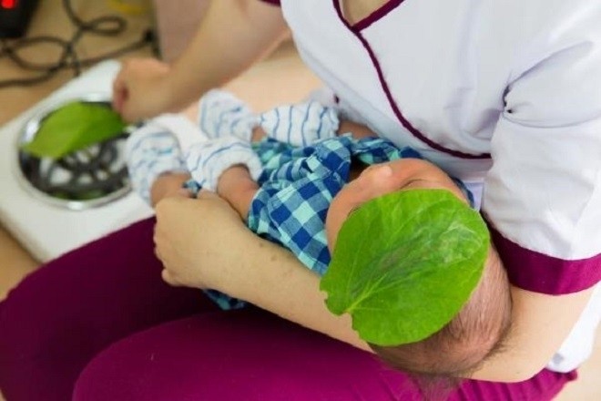 mẹ đắp lá trầu lên đán cho bé