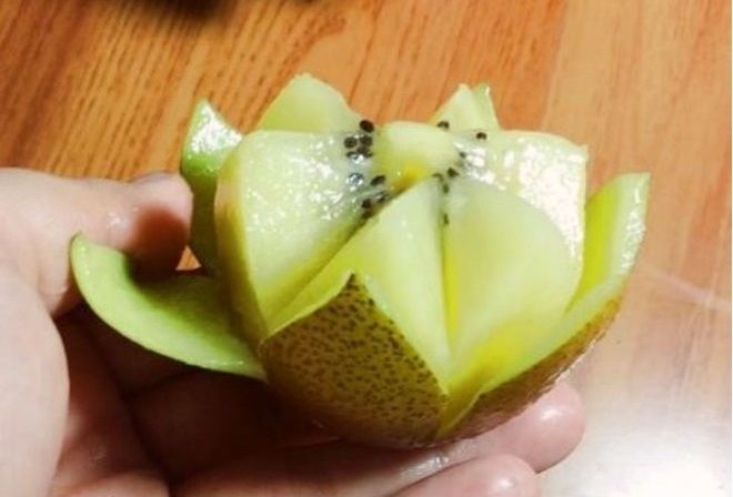 cắt kiwi thành 2 nửa và dùng dao tạo hình cánh hoa
