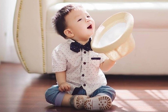 em bé cầm nón