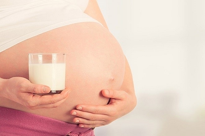mẹ bầu cầm ly sữa trên tay