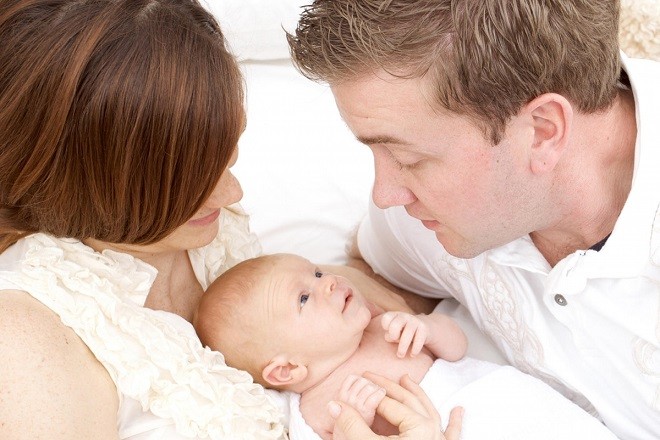 bố mẹ ôm bé mới sinh