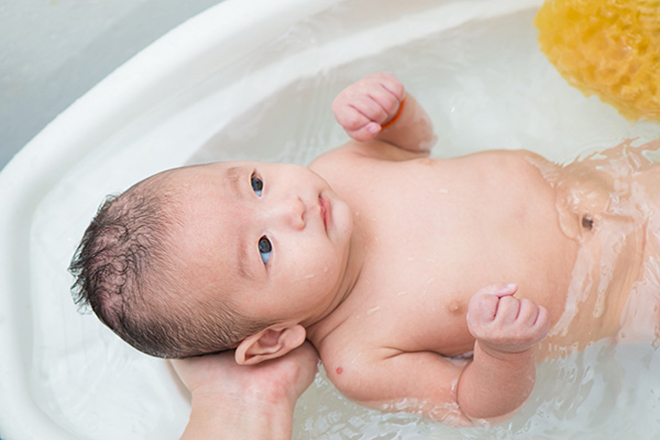 Nhẹ nhàng đặt con vào chậu tắm