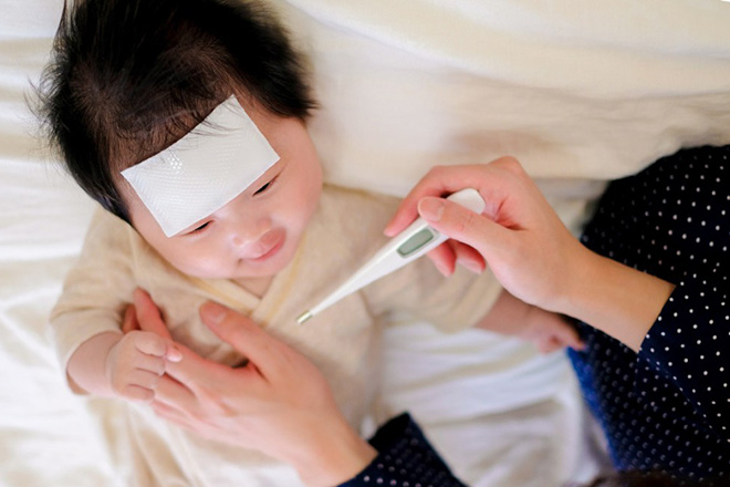Đo nhiệt độ bé sau tiêm phòng