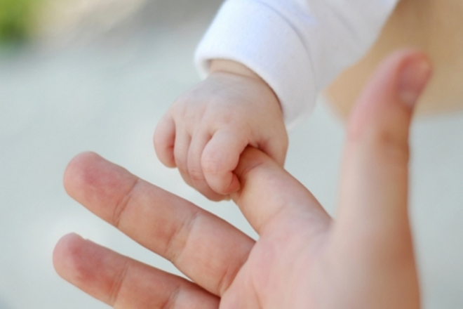 Em bé sơ sinh nắm tay mẹ