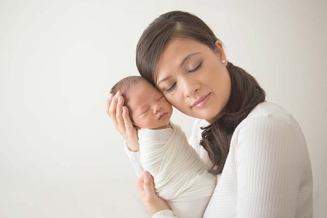 Mẹ bế bé quấn khăn