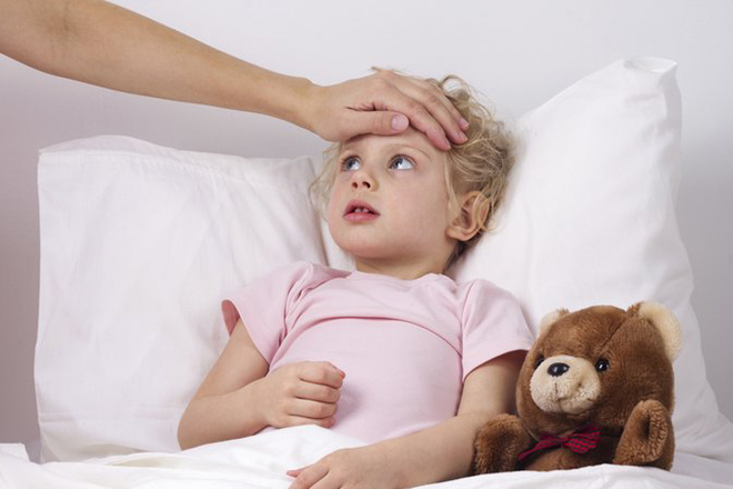 Mẹ rờ đầu bé đang bị sốt