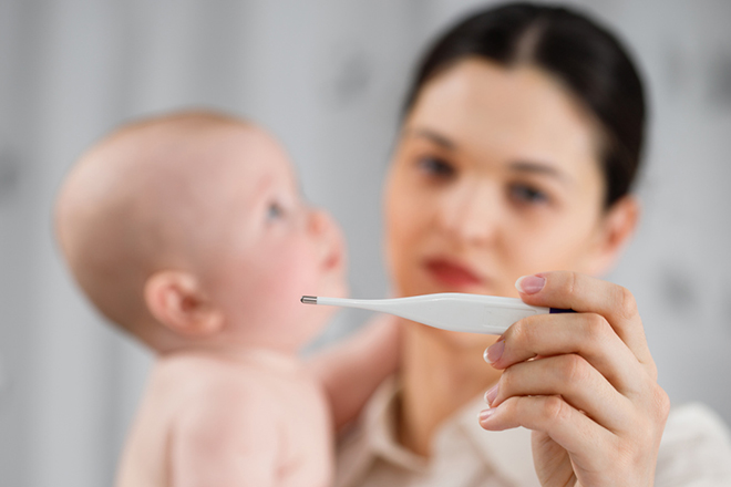 Mẹ đo nhiệt độ cho bé