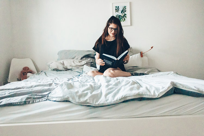 Mẹ ngồi trên giường đọc truyện