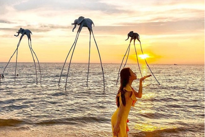 Cô gái váy trắng đứng tại Sunset Sanato Beach Club