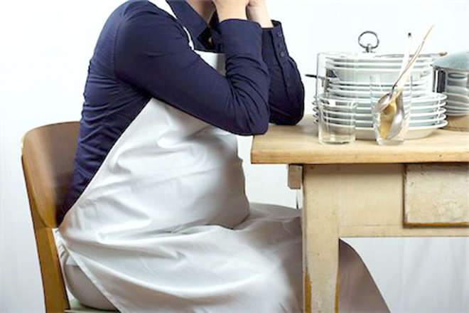 Bà bầu ngồi ở bàn với chồng chén đĩa