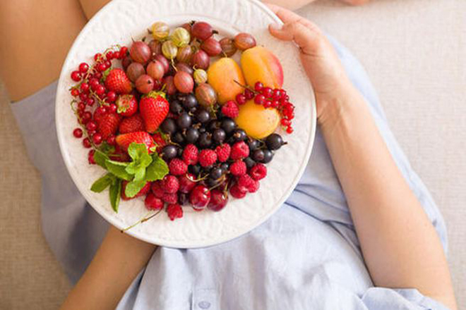 Phụ nữ cầm đĩa trái cây