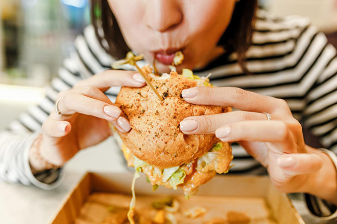 Phụ nữ đang ăn hambuger