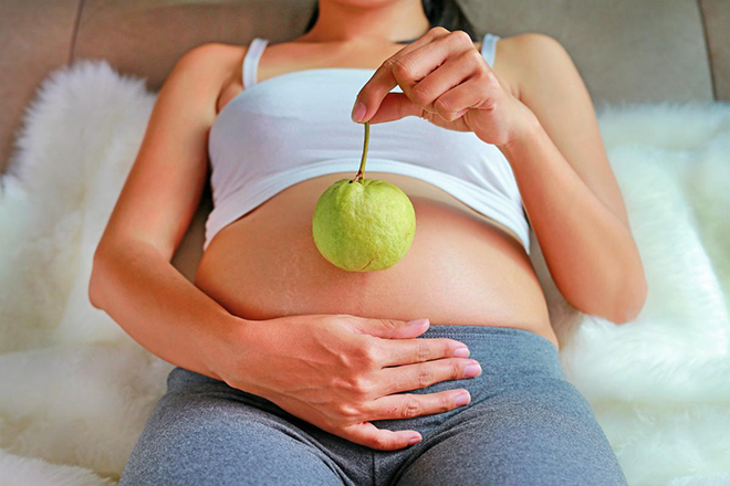 Bà bầu cầm quả ổi