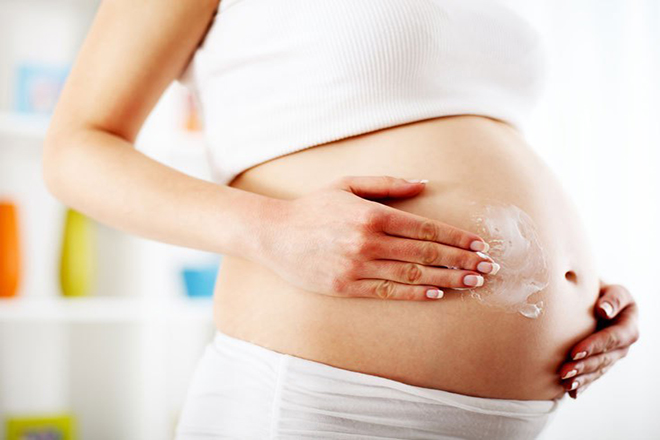 Mẹ bầu bôi kem lên bụng