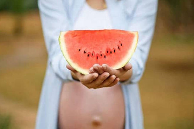 Bà bầu cầm miếng dưa hấu